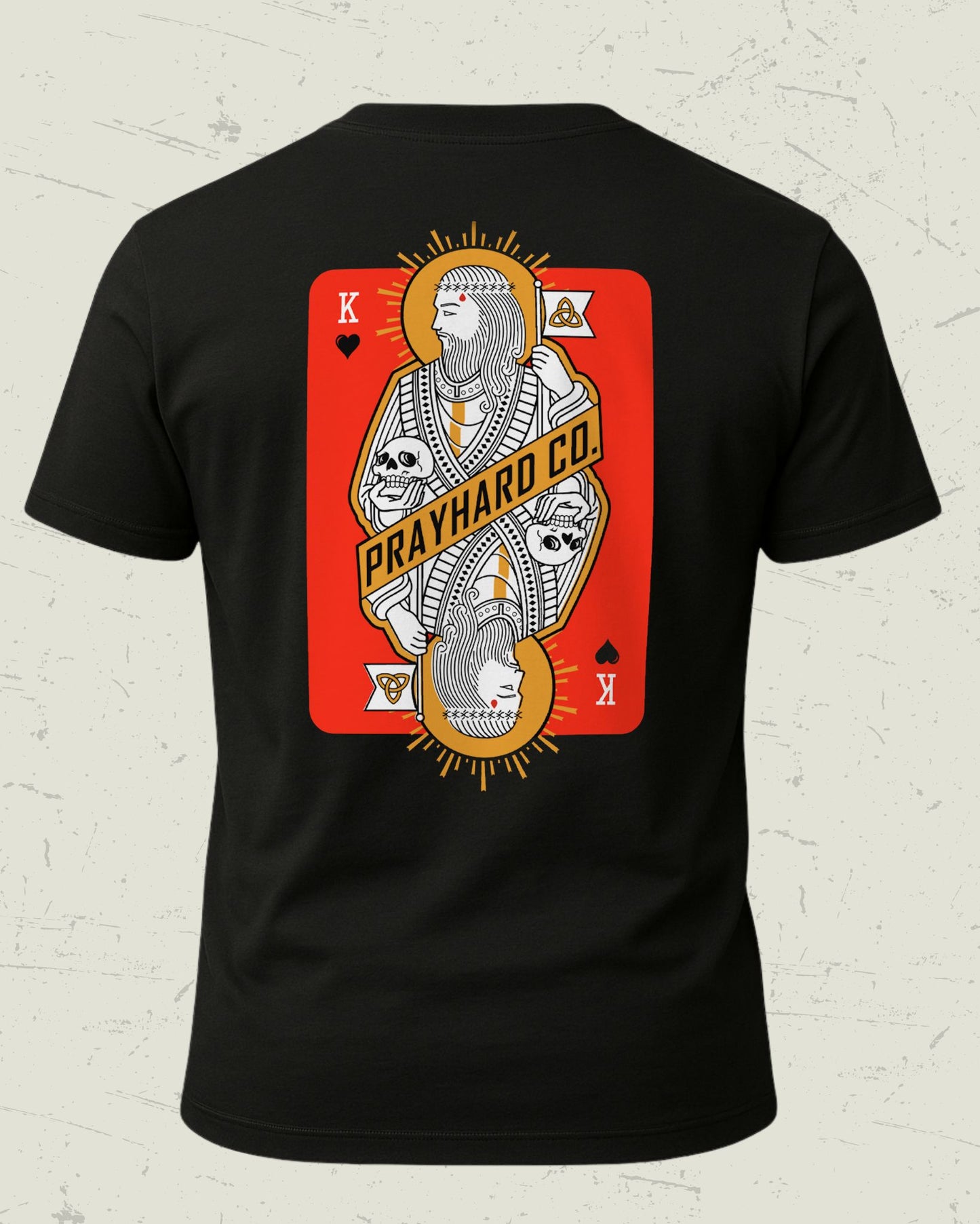 Black t-shirt with a graphic design of a king over death playing card on a textured white background