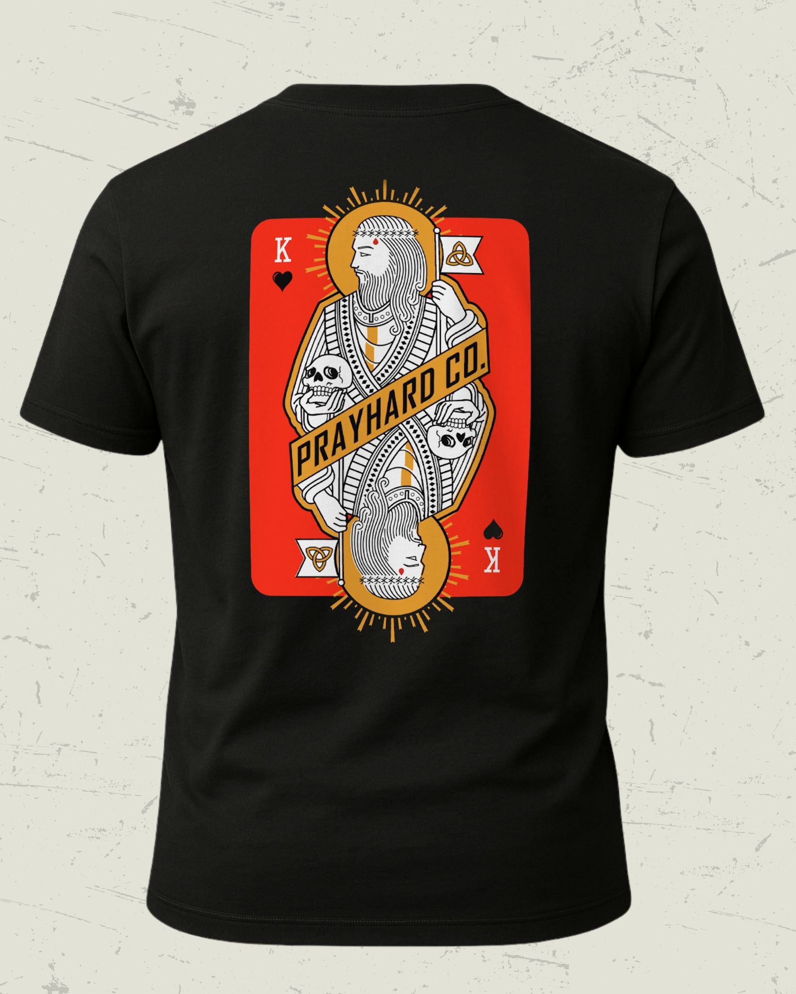 Black t-shirt with a graphic design of a king over death playing card on a textured white background